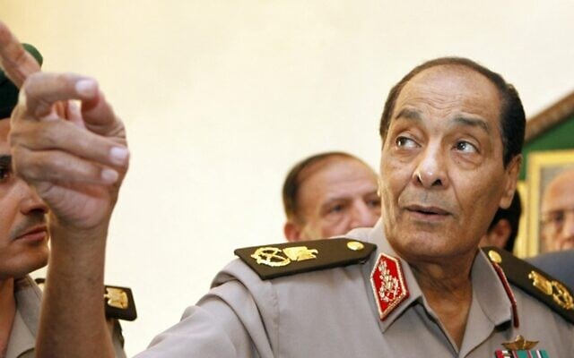 في هذه الصورة التي التقطت في 13 سبتمبر 2011، يشير المشير محمد حسين طنطاوي، رئيس المجلس العسكري الحاكم في مصر، إلى لوحة بينما كان يرافق رئيس الوزراء التركي الزائر في وزارة الدفاع في القاهرة.(Photo by AMR NABIL / POOL / AFP)