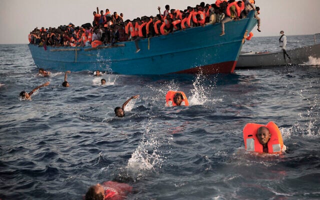توضيحية: في هذه الصورة المحفوظة في 29 أغسطس 2016 ، مهاجرون، معظمهم من إريتريا، يقفزون في الماء من قارب خشبي مزدحم حيث يساعدهم أعضاء منظمة غير حكومية أثناء عملية إنقاذ في البحر الأبيض المتوسط، على بعد حوالي 13 20 كيلومترا، شمال صبراتة، ليبيا. (AP /Emilio Morenati)
