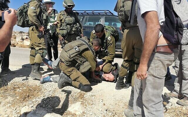 جنود إسرائيليون يعتقلون ناشط اليسار تولي فلينت بالقرب من بلدة الطواني الفلسطينة في جنوب جبل الخليل، 18 سبتمبر، 2021. (Courtesy)