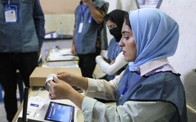 مسؤولو الانتخابات العراقيون يجرون عملية فرز الكتروني للاصوات في مركز اقتراع في اربيل، عاصمة منطقة الحكم الذاتي الكردية في شمال العراق، 10 أكتوبر، 2021. ( SAFIN HAMED / AFP)