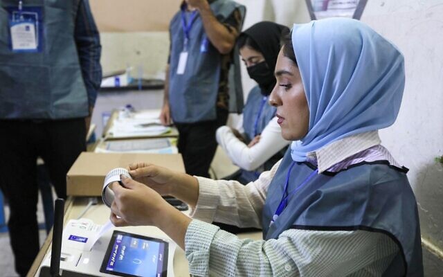 مسؤولو الانتخابات العراقيون يجرون عملية فرز الكتروني للاصوات في مركز اقتراع في اربيل، عاصمة منطقة الحكم الذاتي الكردية في شمال العراق، 10 أكتوبر، 2021. ( SAFIN HAMED / AFP)