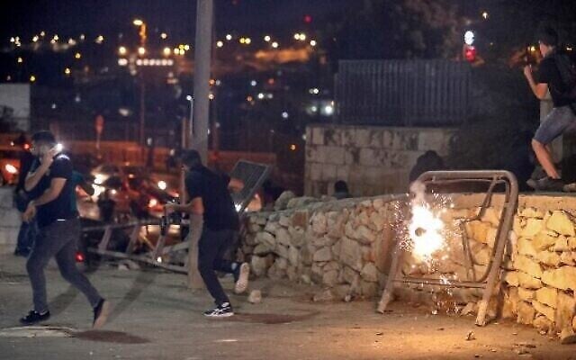 متظاهرون فلسطينيون يفرون بعد انفجار قنبلة صوتية خلال مظاهرة في البلدة القديمة في القدس، 10 أكتوبر 2021 (تصوير AHMAD GHARABLI / AFP)