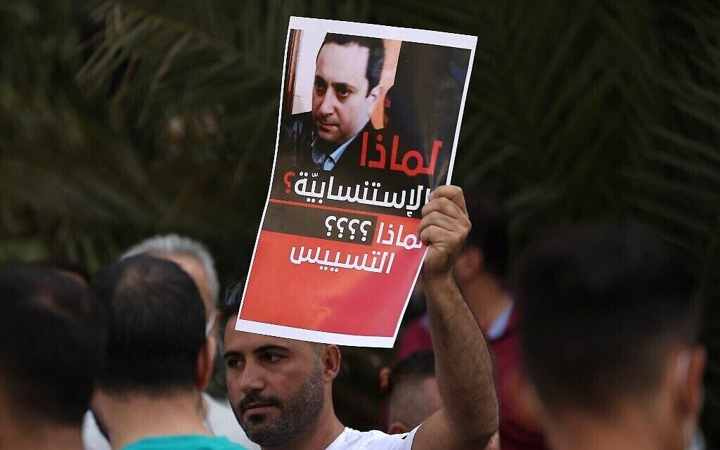 أحد مؤيدي حزب الله وحركة أمل يحمل صورة للقاضي طارق بيطار، محقق تفجير بيروت، بالقرب من قصر العدل في العاصمة بيروت في 14 أكتوبر 2021، خلال تجمع للمطالبة بإقالته. (جوزيف عيد / وكالة الصحافة الفرنسية)