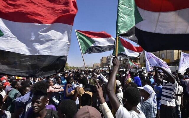 متظاهرون يحملون الأعلام الوطنية السودانية أثناء احتجاجهم على الانقلاب العسكري في السودان، في "شارع 60" شرق العاصمة الخرطوم في 13 نوفمبر، 2021. (AFP)