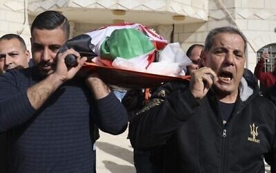 أقارب يشيعون جثمان الفلسطيني عمر أسعد (80 عاما). عُثر على أسعد ميتا بعد اعتقاله وتقييد يديه خلال مداهمة إسرائيلية في قرية جلجيليا بالضفة الغربية، 13 يناير، 2022. ((JAAFAR ASHTIYEH / AFP)