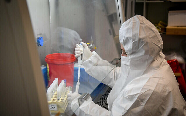 فنيون يجرون اختبارا تشخيصيا لكورونا في معمل في فرع لئوميت للخدمات الصحية في أور يهودا، 21 كانون الثاني 2022 (Yossi Zeliger / Flash90)