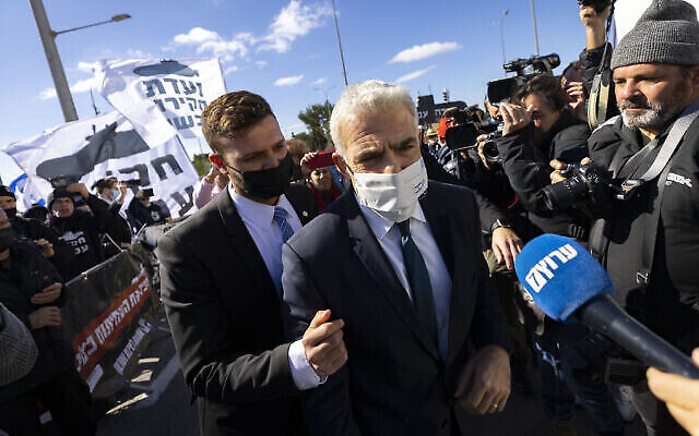 وزير الخارجية يائير لابيد يتواصل مع المشاركين في مظاهرة لدعم تشكيل لجنة تحقيق في قضية الغواصات، من أمام مكتب رئيس الوزراء في القدس، 23 يناير، 2022. (Olivier Fitoussi / Flash90)