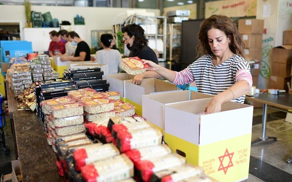 الفنانة الإسرائيلية غاليت غيئات مع متطوعين يعملون على تجهيز رزم مواد غذائية للمحتاجين، 24 نوفمبر، 2020. (Tomer Neuberg / Flash 90) الفنانة الإسرائيلية غاليت غيئات مع متطوعين يعملون على تجهيز رزم مواد غذائية للمحتاجين، 24 نوفمبر، 2020. (Tomer Neuberg / Flash 90)