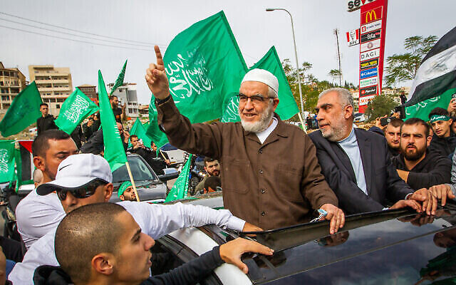 الشيخ رائد صلاح، وسط الصورة، زعيم الفرع الشمالي للحركة الإسلامية في إسرائيل، يصل بعد خروجه من السجن إلى أم الفحم، 13 ديسمبر، 2021. (Flash90)