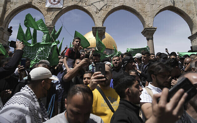فلسطينيون يرددون شعارات ويلوحون بأعلام حماس بعد صلاة الجمعة خلال شهر رمضان المبارك، بعد ساعات من اشتباك الشرطة الإسرائيلية مع المتظاهرين في الحرم القدسي في البلدة القديمة بالقدس، 22 أبريل، 2022 (AP Photo / Mahmoud Illean)