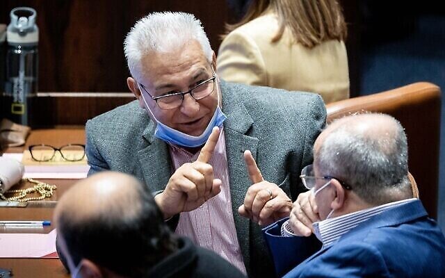 عضو الكنيست مازن غنيم (وسط الصورة) يتحدث مع عضو الكنيست أحمد الطيبي خلال جلسة في الكنيست، 5 يناير، 2022. (Yonatan Sindel / Flash90)