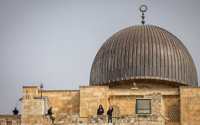فلسطينيون يظهرون يافطات النصر تحت قبة المسجد الاقصى، في الحرم القدسي في البلدة القديمة، 17 ابريل 2022 (Yonatan Sindel / Flash90)
