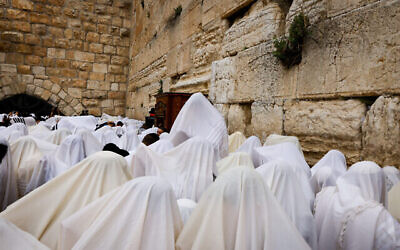 المصلون اليهود يغطون أنفسهم بشالات الصلاة أثناء مشاركتهم في أداة صلاة "بركة الكهنة" بمناسبة عيد الفصح اليهودي عند الحائط الغربي في البلدة القديمة بالقدس، 20 أبريل، 2022. (Olivier Fitoussi / Flash90)