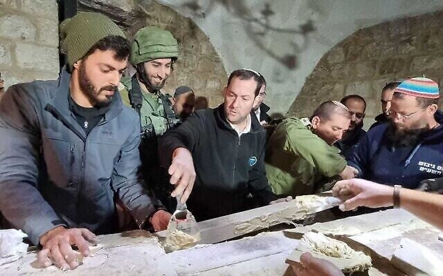 رئيس المجلس الإقليمي السامرة يوسي دغان ، وسط الصورة، في موقع "قبر يوسف" في الضفة الغربية خلال عملية  نادرة لترميم الموقع في وضح النهار، 13 أبريل، 2022. (Roee Chedi/Samaria Regional Council)
