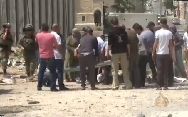 أشخاص يحيطون بجثمان غادة سباتين، بعد لحظات من مقتلها بالرصاص في قرية حوسان بالضفة الغربية، 10 أبريل 2022 (Twitter screenshot; used in accordance with Caluse 27a of the copyright law)