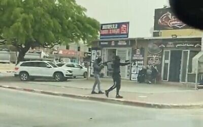 لقطة شاشة من مقطع فيديو يظهر على ما يبدو مسلحين يفتحون النار باتجاه متجر في رهط، 24 أبريل، 2022. (Screen grab / Kan)