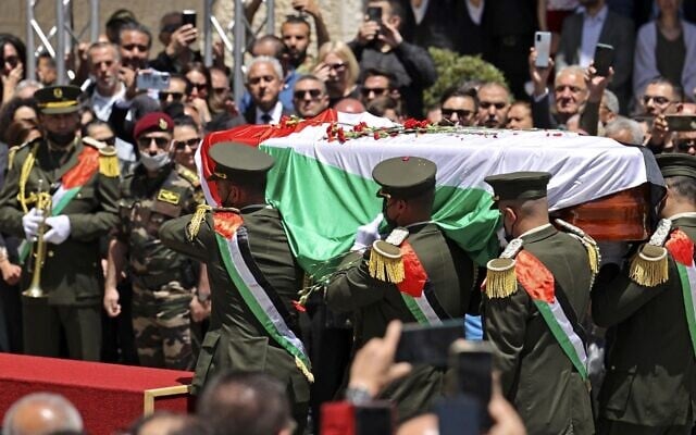 الحرس الرئاسي الفلسطيني يحمل نعش صحفية الجزيرة شيرين أبو عاقله خلال جنازة رسمية في المقر الرئاسي في مدينة رام الله بالضفة الغربية، 12 مايو، 2022. (ABBAS MOMANI / AFP)
