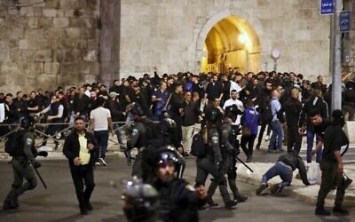 اشتباكات بين القوات الإسرائيلية والفلسطينيين في أعقاب تشييع جنازة وليد الشريف، 23 عاما، متأثرا بجراح أصيب بها الشهر الماضي خلال مواجهات مع الشرطة الإسرائيلية خارج المسجد الأقصى في الحرم القدسي، في 16 مايو 2022 (تصوير أحمد غرابلي / وكالة فرانس برس)