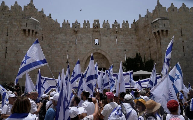 إسرائيليون يلوحون بالأعلام الإسرائيلية أمام باب العامود خارج البلدة القديمة في القدس بمناسبة الاحتفال بـ"يوم أورشليم"، 29 مايو، 2022. (AP Photo / Mahmoud Elean) إسرائيليون يلوحون بالأعلام الإسرائيلية أمام باب العامود خارج البلدة القديمة في القدس بمناسبة الاحتفال بـ"يوم أورشليم"، 29 مايو، 2022. (AP Photo / Mahmoud Elean)