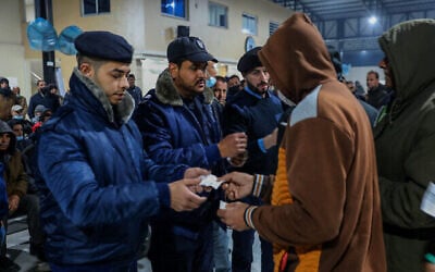عمال فلسطينيون ينتظرون عند معبر إيريز في بيت حانون بشمال قطاع غزة في انتظار دخول إسرائيل للعمل، 13 مارس، 2022. (Attia Muhammed / Flash90)