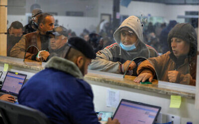 عمال فلسطينيون عند معبر إيريز في بيت حانون، شمال قطاع غزة، في انتظار دخول إسرائيل للعمل، 13 مارس، 2022. (Attia Muhammed / Flash90)