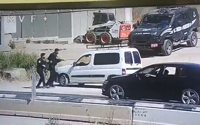الشرطة تستجوب رجلا فلسطينيا بالقرب من مخيم الفوار بالضفة الغربية، جنوب الخليل في 8 يونيو، 2022. خطف المشتبه به بندقية أحد الضباط قبل مغادرته السيارة. (لقطة شاشة: Twitter)