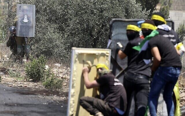 توضيحية: فلسطينيون يستخدمون حواجز مؤقتة خلال مواجهات مع القوات الإسرائيلية في أعقاب مظاهرة في قرية كفر قدوم، بالقرب من مستوطنة كدوميم اليهودية في الضفة الغربية، 1 يوليو، 2022. (Jaafar Ashtiyeh / AFP)