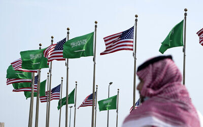 رجل يقف تحت العلمين الأمريكي والسعودي قبل زيارة الرئيس الأمريكي جو بايدن، في ساحة في جدة، المملكة العربية السعودية، 14 يوليو 2022 (AP / Amr Nabil)