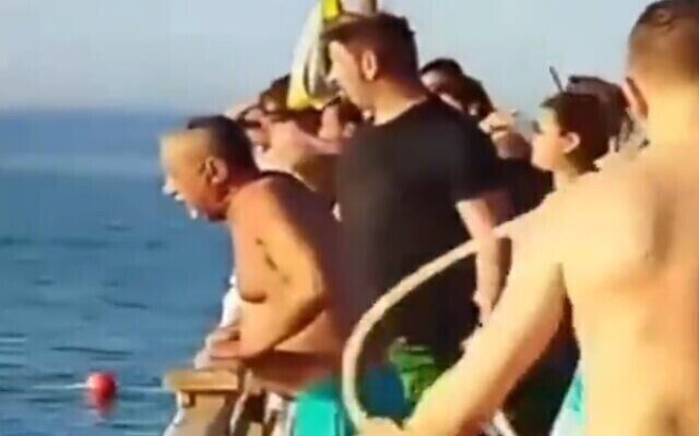 سياح يشاهدون امرأة وهي تحاول للعودة إلى الشاطئ بعد تعرضها لهجوم قرش في مصر، 1 يوليو، 2022. (Screen grab) سياح يشاهدون امرأة وهي تحاول للعودة إلى الشاطئ بعد تعرضها لهجوم قرش في مصر، 1 يوليو، 2022. (Screen grab)