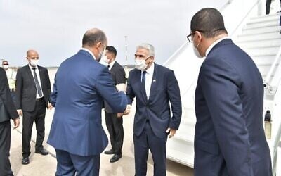 نائب وزير الخارجية المغربي محسن الجزولي يستقبل وزير الخارجية يائير لبيد (وسط) في مطار الرباط سلا الدولي، 11 أغسطس، 2021. (Shlomi Amsalem, GPO)