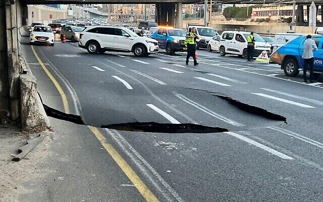 الشرطة في موقع حفرة ظهرت في طريق أيالون السريع جراء انهيار أرضي في تل أبيب، 17 سبتمبر ، 2022. (Avshalom Sassoni / Flash90)