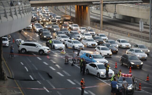 الشرطة في موقع حفرة ظهرت في طريق أيالون السريع جراء انهيار أرضي في تل أبيب، 17 سبتمبر ، 2022. (Avshalom Sassoni / Flash90)