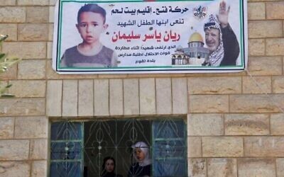 فلسطينيون يشاهدون جنازة ريان سليمان البالغ من العمر سبع سنوات، والذي توفي في اليوم السابق على هامش عملية تفتيش للجيش الإسرائيلي في بلدته تقوع، جنوب بيت لحم بالضفة الغربية، 30 سبتمبر، 2022. (HAZEM BADER / وكالة فرانس برس)