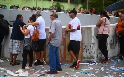 الناس يصطفون في طابور للتصويت في مركز اقتراع خلال الانتخابات التشريعية والرئاسية البرازيلية، بالقرب من روسينها فافيلا في ريو دي جانيرو ، البرازيل، 2 أكتوبر، 2022.  (ANDRE BORGES / AFP)