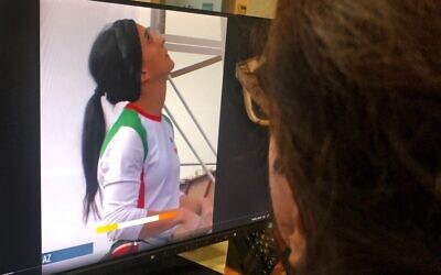 امرأة تنظر إلى شاشة تعرض مقطع فيديو لمسابقة تسلق دولية في سيول، كوريا الجنوبية، شاركت فيها المتسلقة الإيرانية إلناز ركابي بدون حجاب، في العاصمة القبرصية نيقوسيا، 18 أكتوبر 2022 (AFP)