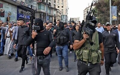 مسلحون في جنازة القتلى في اشتباكات اندلعت بعد عملية ليلية اسرائيلية ضد جماعة "عرين الأسود"  في مدينة نابلس بالضفة الغربية، 25 أكتوبر، 2022. (RONALDO SCHEMIDT / AFP)