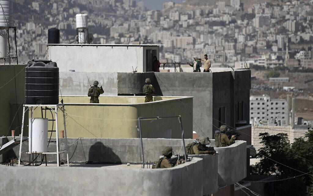 قوات الأمن الإسرائيلية تنتشر على سطح منزل فلسطيني خلال عملية تفتيش في سالم بالقرب من مدينة نابلس بالضفة الغربية، في أعقاب هجوم إطلاق نار تبناه فصيل "عرين الأسود"، 2 أكتوبر، 2022. (AP / Majdi Mohammed) قوات الأمن الإسرائيلية تنتشر على سطح منزل فلسطيني خلال عملية تفتيش في سالم بالقرب من مدينة نابلس بالضفة الغربية، في أعقاب هجوم إطلاق نار تبناه فصيل "عرين الأسود"، 2 أكتوبر، 2022. (AP / Majdi Mohammed)