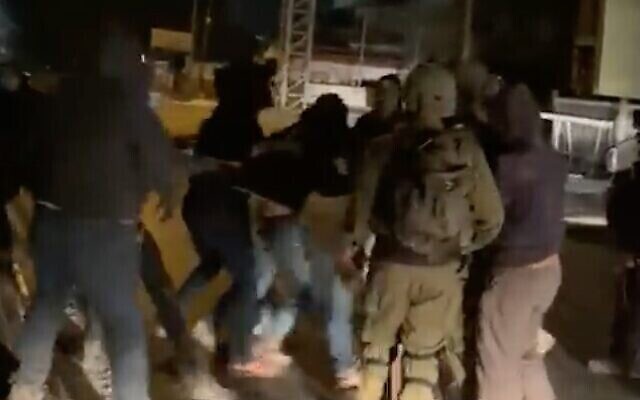 لقطة شاشة من مقطع فيديو لمستوطنين إسرائيليين يشتبكون مع جنود إسرائيليين في بلدة حوارة الفلسطينية بالضفة الغربية، 19 أكتوبر، 2022. (Twitter video; used in accordance with Clause 27a of the Copyright Law)