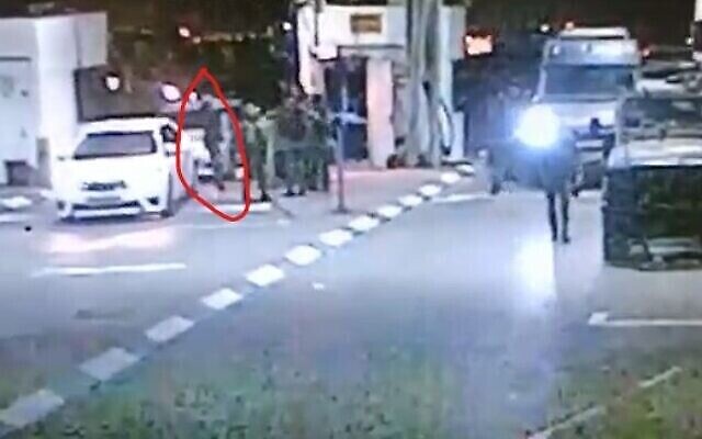 مسلح فلسطيني (محاط بدائرة باللون الأحمر) يقترب من مجموعة من جنود الجيش الإسرائيلي وحراس مدنيين، دون أن يتم رصده كما يبدو، عند نقطة تفتيش في القدس الشرقية، 8 أكتوبر، 2022. (Screencapture) مسلح فلسطيني (محاط بدائرة باللون الأحمر) يقترب من مجموعة من جنود الجيش الإسرائيلي وحراس مدنيين، دون أن يتم رصده كما يبدو، عند نقطة تفتيش في القدس الشرقية، 8 أكتوبر، 2022. (Screencapture)