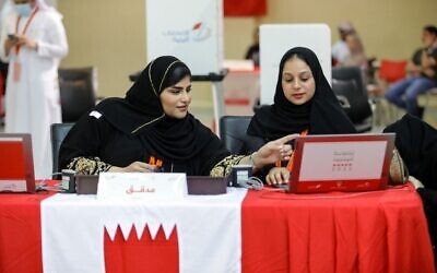 مدققات في الانتخابات البحرينية يستعددن لاستقبال الناخبين في مركز اقتراع بجزيرة المحرق شمال العاصمة المنامة خلال الانتخابات البرلمانية، 12 نوفمبر 2022 (AFP)