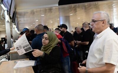 أشخاص يسجلون وصولهم في مطار بن غوريون الدولي في تل أبيب، لأول رحلة تجارية مباشرة من إسرائيل إلى الدوحة لحضور بطولة كأس العالم 2022، 20 نوفمبر 2022 (Tomer Neuberg / Flash90)