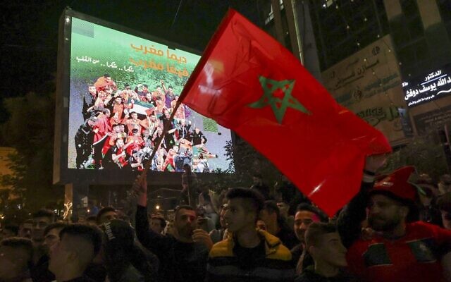 فلسطينيون يحتفلون بفوز المغرب على البرتغال في شوارع مدينة الخليل بالضفة الغربية بعد مباراة ربع نهائي كأس العالم في قطر، 10 ديسمبر 2022 (HAZEM BADER / AFP)