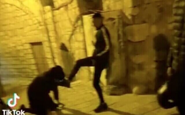 رجل حريدي ينحني ويقبل قدم فتى فلسطيني في البلدة القديمة في القدس. قُبض على قاصرين فلسطينيين في الحادثة التي وقعت في الأول من ديسمبر، 2022. (Screen capture / Twitter) رجل حريدي ينحني ويقبل قدم فتى فلسطيني في البلدة القديمة في القدس. قُبض على قاصرين فلسطينيين في الحادثة التي وقعت في الأول من ديسمبر، 2022. (Screen capture / Twitter)
