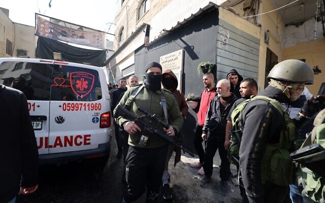 مسلحون ومدنيون فلسطينيون يتجمعون حول سيارة اسعاف بعد مداهمة للقوات الاسرائيلية على مخيم جنين للاجئين في الضفة الغربية، 26 يناير 2023 (JAAFAR ASHTIYEH / AFP)