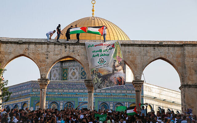 رفع العلم الفلسطيني ولافتة لحركة حماس بعد صلاة عيد الاضحى في الحرم القدسي، 20 يوليو، 2021. (Jamal Awad / Flash90) رفع العلم الفلسطيني ولافتة لحركة حماس بعد صلاة عيد الاضحى في الحرم القدسي، 20 يوليو، 2021. (Jamal Awad / Flash90)