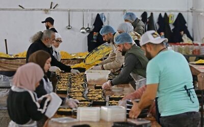 متطوعون يعدون وجبات الطعام للمتضررين من الزلزال المدمر في مدينة حلب السورية الشمالية الخاضعة لسيطرة الحكومة، 21 فبراير 2023 (LOUAI BESHARA / AFP)