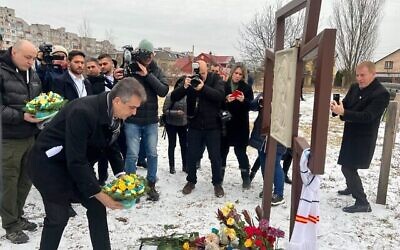 وزير الخارجية إيلي كوهين يضع إكليلا من الزهور على مقبرة جماعية تضم 116 مدنيا قتلوا على يد الروس في بوتشا، كييف، أوكرانيا، 16 فبراير، 2023. (Lazar Berman / Times of Israel)