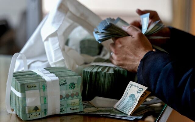 موظف يعد ليرة لبنانية في مكتب صرافة في بيروت، 20 يناير 2023 (JOSEPH EID / AFP)
