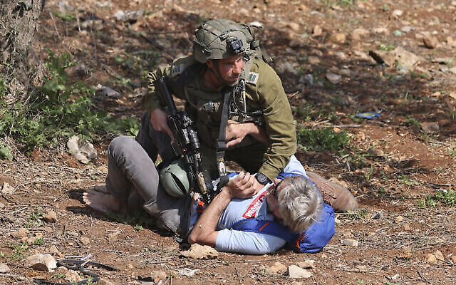 جندي يشتبك مع متظاهر أثناء تظاهرة نشطاء سلام فلسطينيين وإسرائيليين عند مدخل حوارة في الضفة الغربية، 3 مارس، 2023. (Jaafar ASHTIYEH / AFP) جندي يشتبك مع متظاهر أثناء تظاهرة نشطاء سلام فلسطينيين وإسرائيليين عند مدخل حوارة في الضفة الغربية، 3 مارس، 2023. (Jaafar ASHTIYEH / AFP)