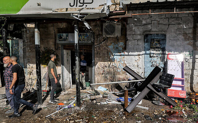من الأرشيف: اشخاص يتجمعون خارج مبنى خضع للتفتيش في اعقاب مداهمة للجيش الإسرائيلي في مخيم جنين بالضفة الغربية، 18 ابريل، 2023. (JAAFAR ASHTIYEH / AFP)